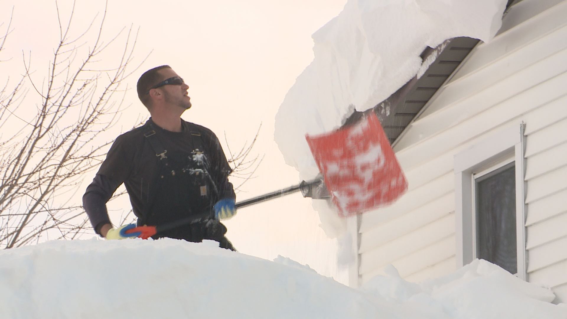 Busy Contractor Crews Shoveling Snow from Roofs